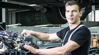 Automobil-Mechatroniker:in EFZ Fachrichtung Personenwagen während der Arbeit.